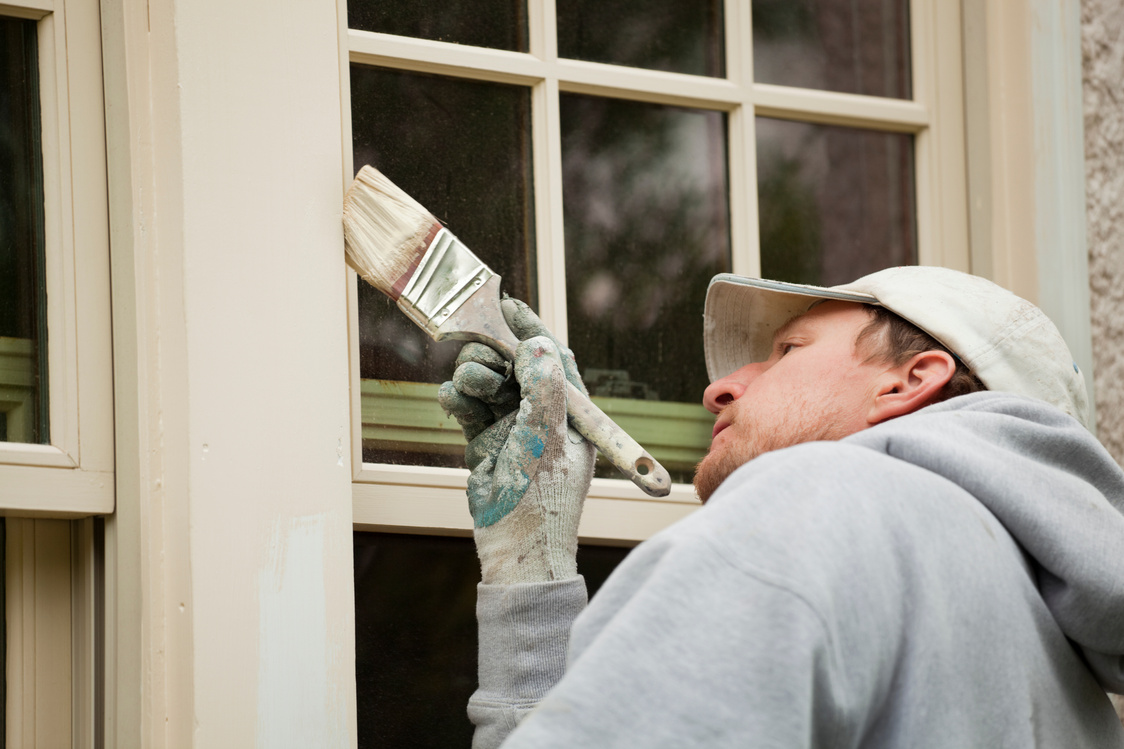 House Painter Working on Exterior Home Maintenance Improvement Painting Work
